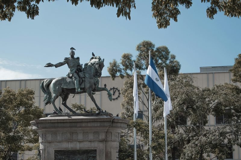 El Salvador — estatua y bandera nacional